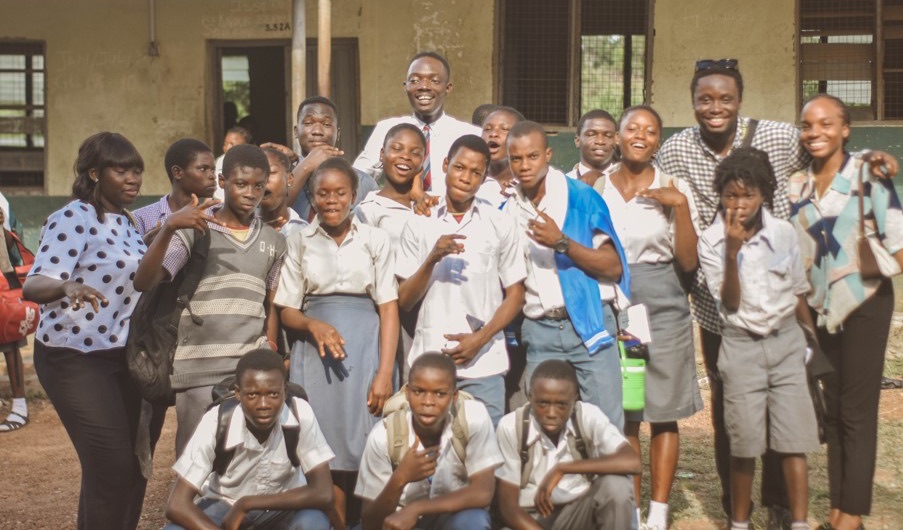 Students and FESAC volunteers gathered for a group photo outside a school building